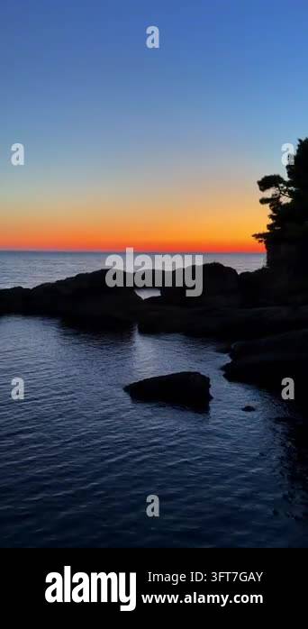 Fading Rocks Silent ocean meets twilight's soft glow. Rocks stand dark against ...