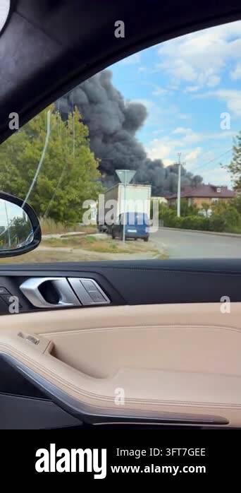 Black smoke billows from a burning truck. Driver watches the scene from ...