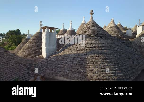 Alberobello, Italy. Walking past whitewashed Trulli houses in Puglia ...