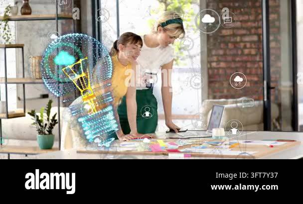 Two women creating in loft, standing woman tapping trackpad, finalizing ...