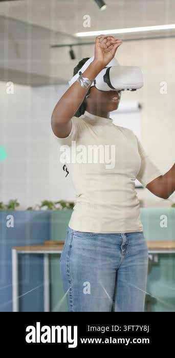 Vertical video: Woman wearing VR headset raising hand and manipulating ...