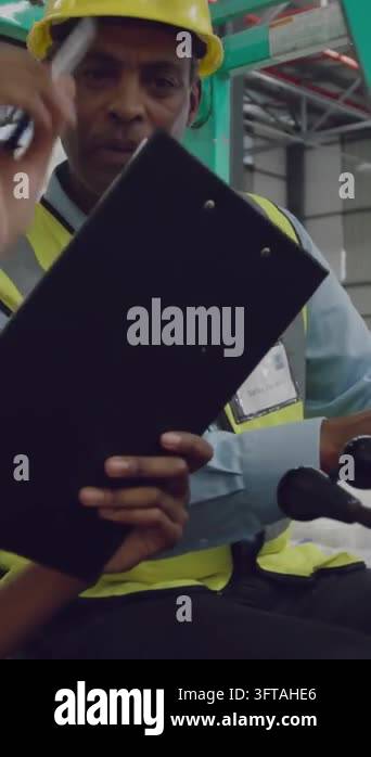 Male worker taking clipboard from peer, signing to approve eco form ...