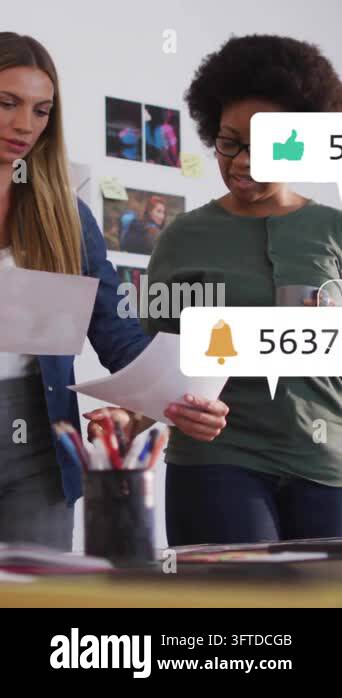 Animation of media icons over diverse female colleagues discussing work ...