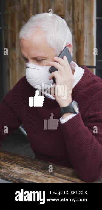 Animation of like icons over caucasian man wearing face mask, using ...