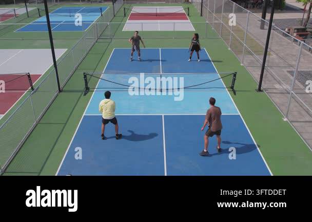 Back Outside Aerial view of four people playing pickleball on an outdoor court ...