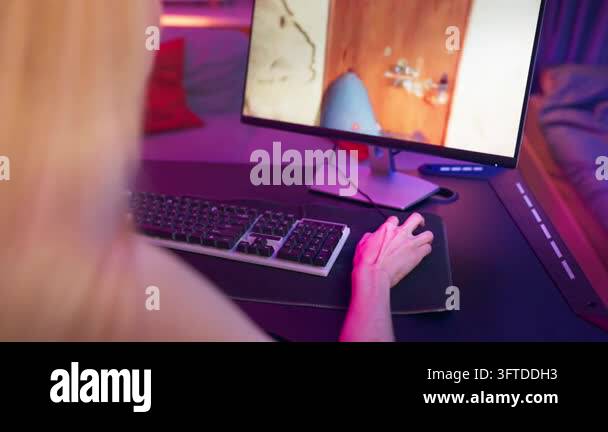 Close-up of a person playing a video game on a computer, using a ...