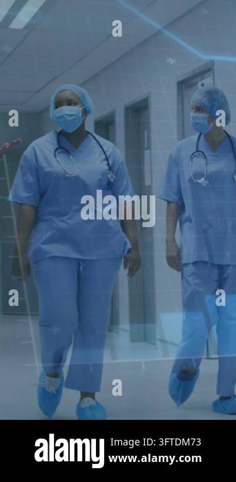Vertical video: Camera tracking as two medics walking ward rounds, blue ...