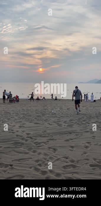 Eye-level sunset view of sandy beach with textured footprints in ...