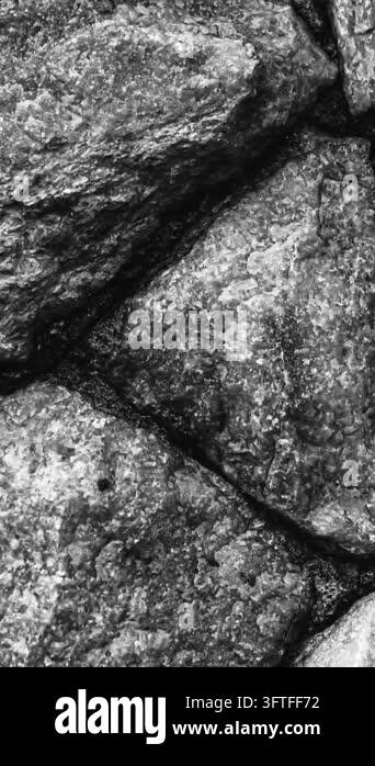 A detailed, close-up view of a weathered, irregular stone wall pattern ...