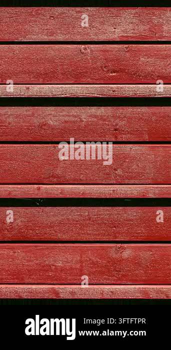 Close up texture of aged red painted wooden planks arranged vertically ...