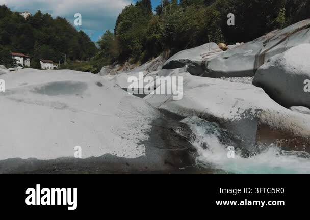 Ground level view of turbulent alpine river with foaming rapids ...