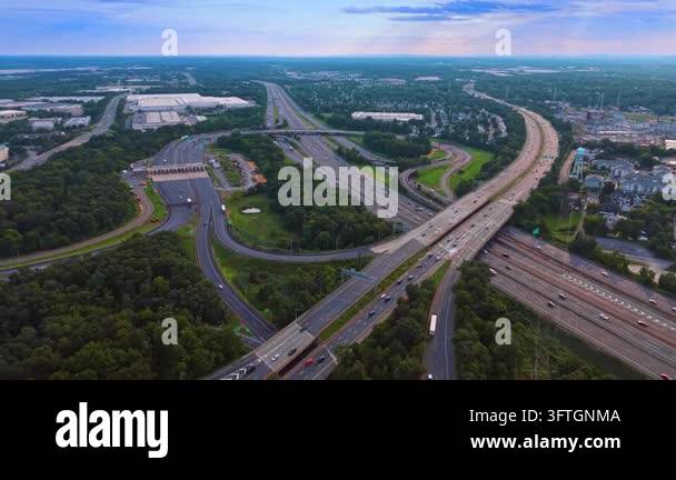 Highway interchange with loop ramps across a wooded landscape. Elevated ...