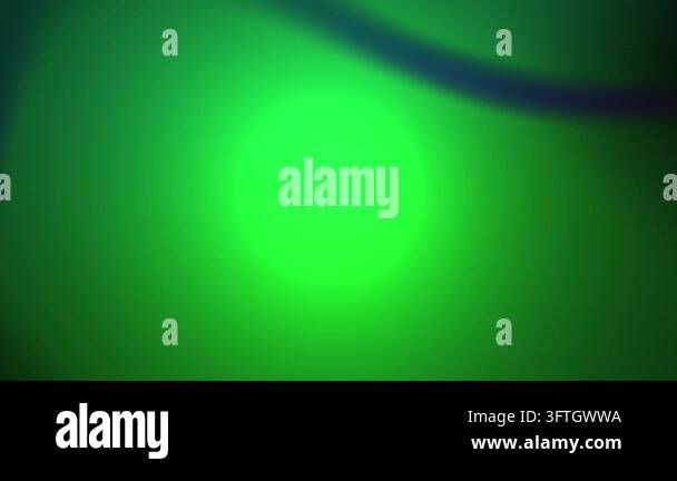 Abstract green blurred light glowing softly across a dark background ...