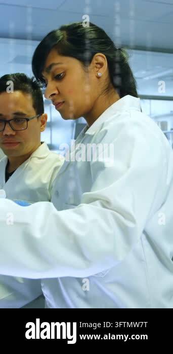Vertical video: Lab tech picking vial, pipetting for tracking while ...
