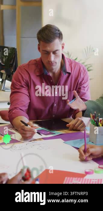 Designer using tablet, pausing as green eco icons rise, tracking and ...