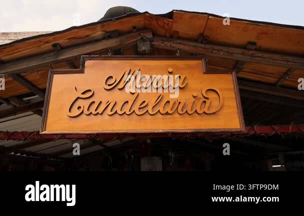 Maria In Script A wood framed shop sign hanging under a roof structure displaying the ...