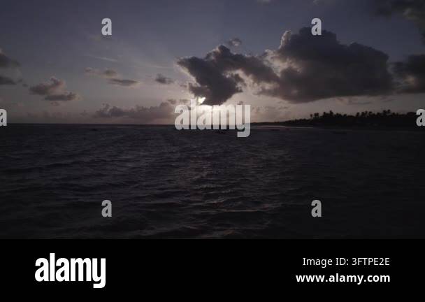 Sunset over ocean with clouds and shoreline Stock Video Footage - Alamy