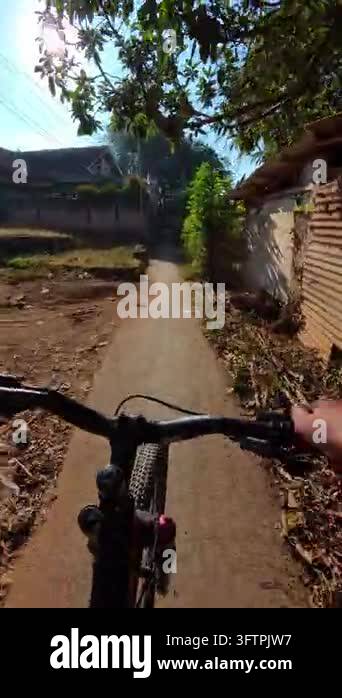 First-person Video of Bicyclist rides down narrow, sunlit alleyway ...