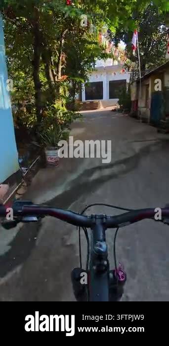First-person Video of Bicyclist rides down narrow, sunlit alleyway ...