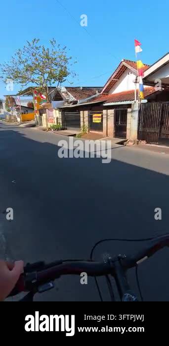 First-person Video of Bicycle rides down quiet village street. Hand ...