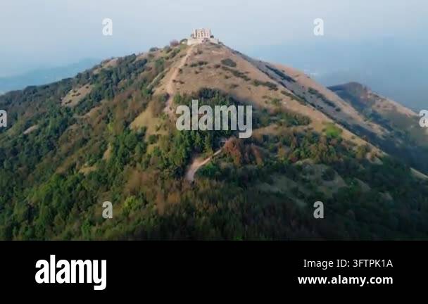 Aerial drone footage flying over a winding path leading to a stone ...