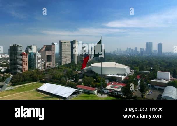 Tsll Tree Aerial view of the Mexican flag waving in front of a modern city ...