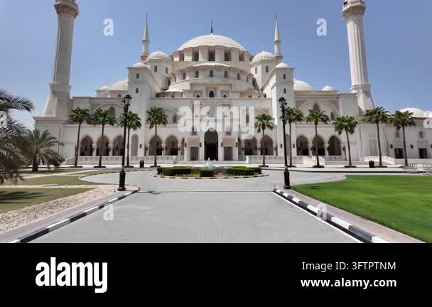 Tsll Tree Wide shot of a grand mosque with tall minarets and a large dome ...