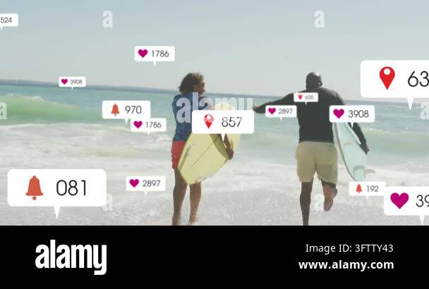 Two surfers starting jog into surf carrying yellow and teal boards ...