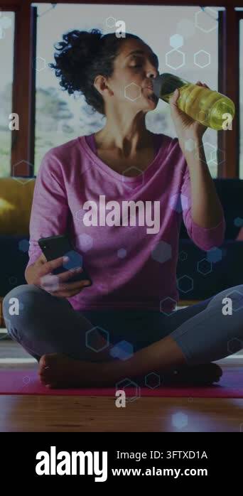 Vertical video: Woman raising bottle while scrolling phone and tracking ...
