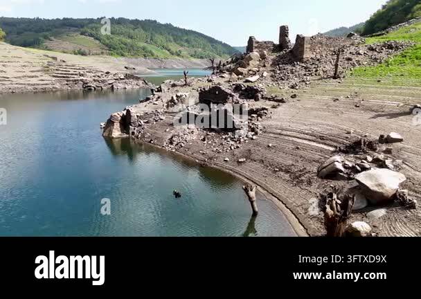 Aerial view of the ruins of an old flooded village appearing due to low ...
