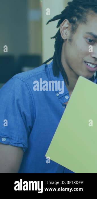 Vertical video: Man lifting yellow laptop and reading, code overlays ...