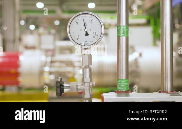 Close-up of a pressure gauge on industrial pipes at the CERN facility ...