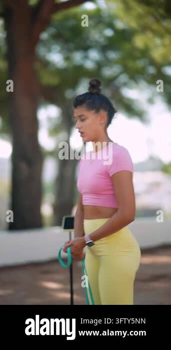 Vertical eye-level view of young woman in pink and yellow activewear ...
