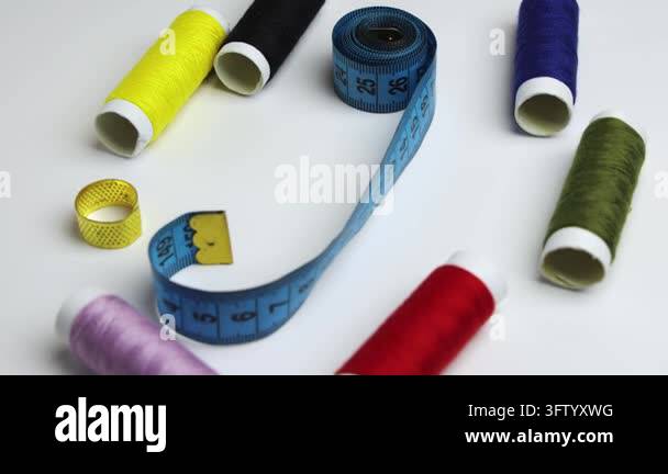 Flat lay of assorted colorful sewing thread spools with a tape measure ...
