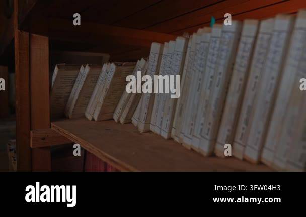 Old archive folders with radio reel recordings stand on wooden shelves ...