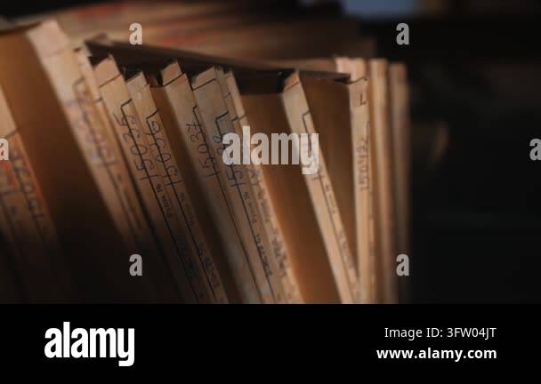 Old archive folders with radio reel recordings stand on wooden shelves ...