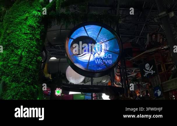 Aqua Wave sign glows above an indoor water park attraction as tropical ...
