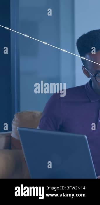 Vertical video: Typing man in polo with specs on sofa, laptop with blue ...