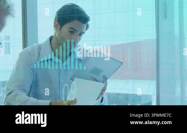 Business analyst scanning tablet reading papers in glass office as teal ...