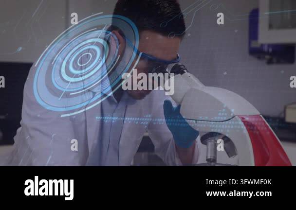 Male lab tech peering into eyepiece, tuning focus, analyzing sample ...