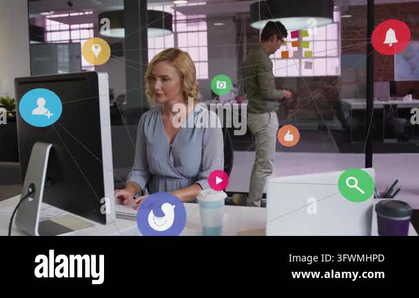 Woman typing at keyboard, causing floating icons while man arranging ...