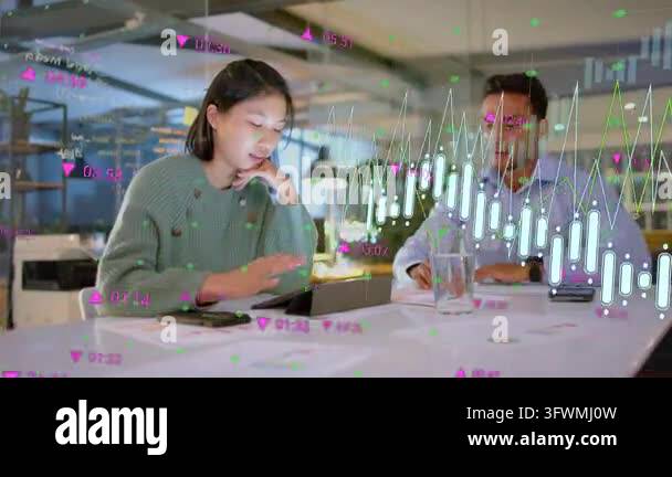 Woman tapping tablet sparking candlestick charts overlay while man ...
