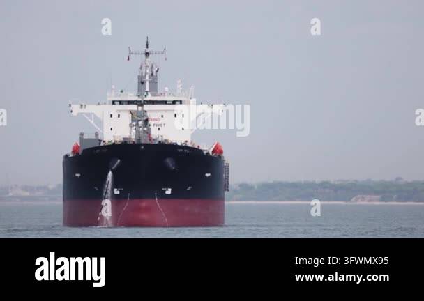 Wwhile Huge crude oil tanker sailing on the ocean while releasing ballast ...