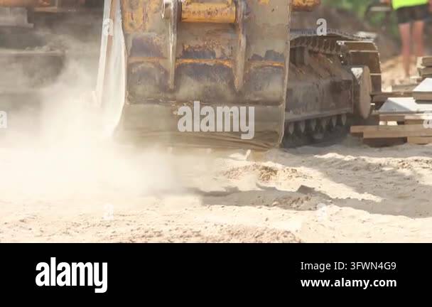 Heavy construction machinery working, digging and moving sand with its ...