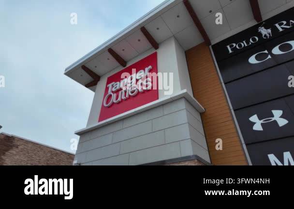 Exterior view of a Tanger Outlets sign on a modern shopping center ...