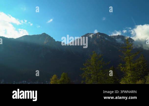 Majestic mountain range under a clear blue sky with trees in the ...