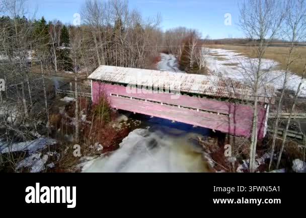 Pink covered bridge over frozen river landscape Stock Video Footage - Alamy