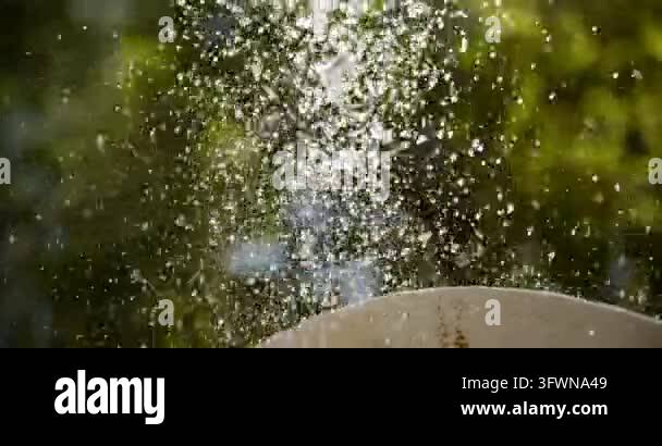 Close-up of water droplets splashing and suspended mid-air above a ...