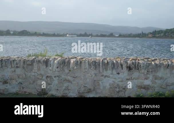 An old, skillfully hand-built stone wall separates the salt lagoon from ...