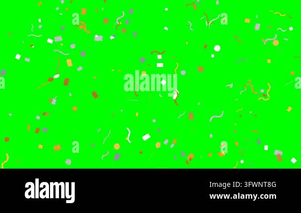 Colorful confetti pieces fall rapidly against a solid green screen ...